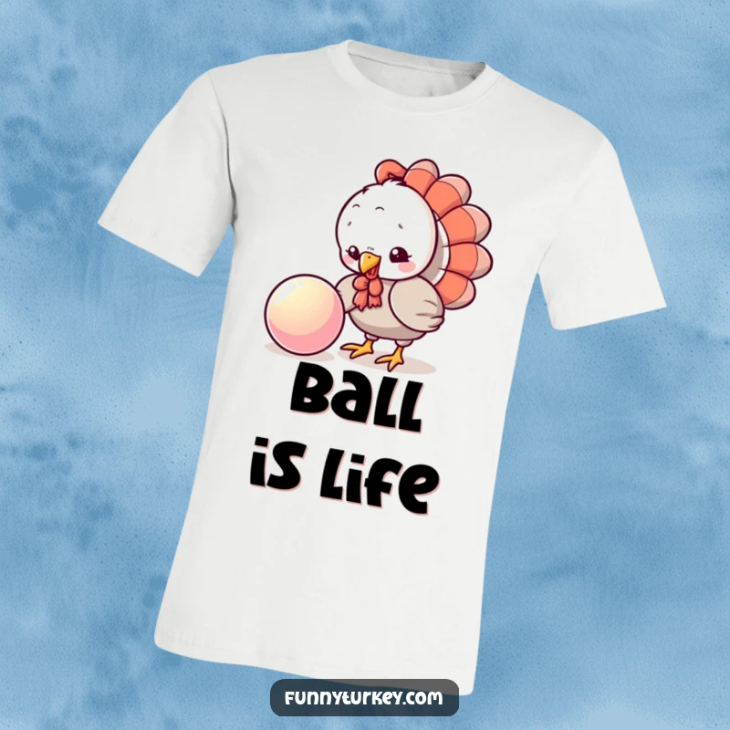 Funny Turkey Ball T-Shirt: A playful kawaii turkey pecks curiously at a shiny, bouncing ball, capturing a moment of humorous engagement.